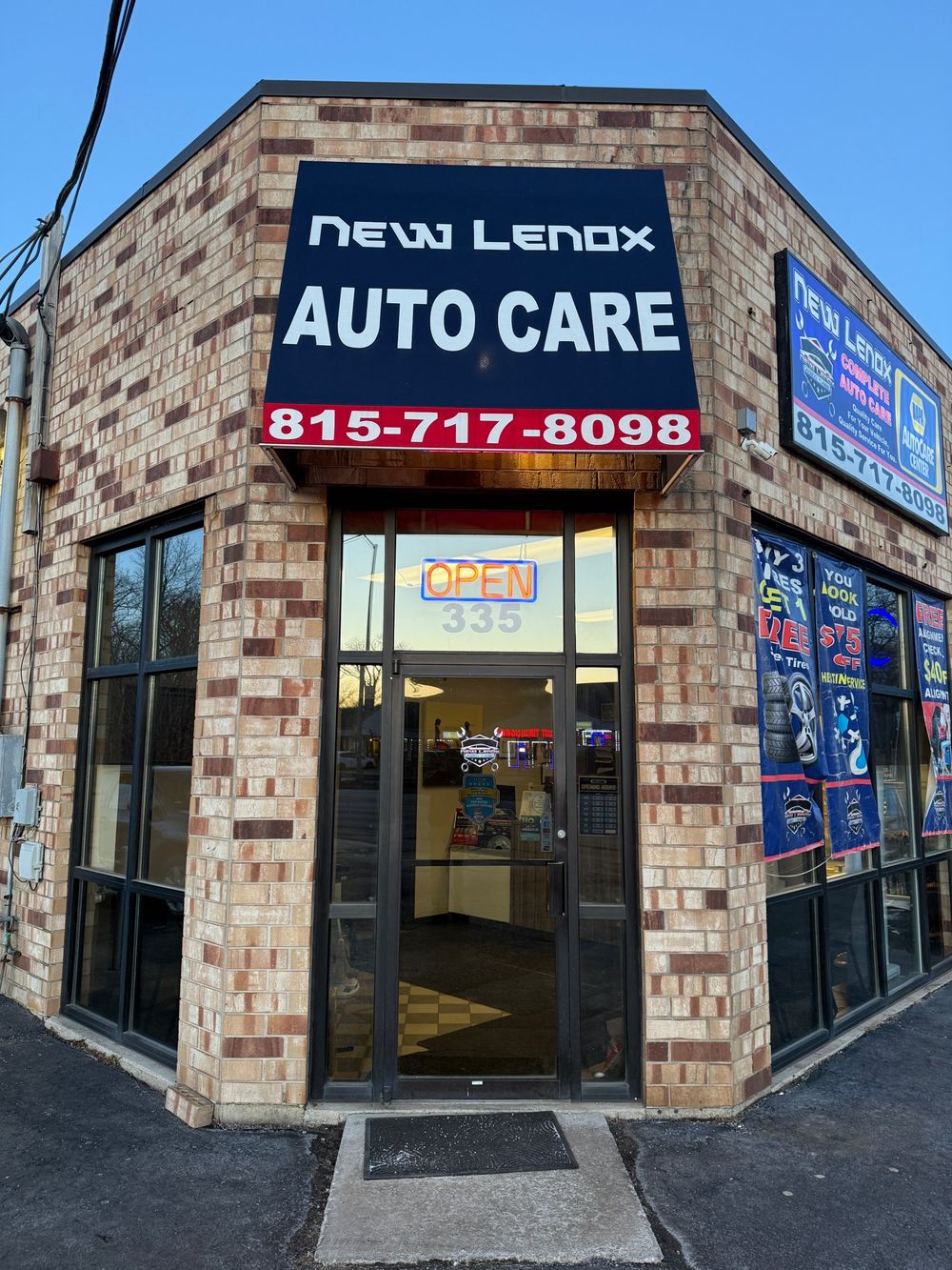 Front entrance of New Lenox Auto Care with the phone number on the awning