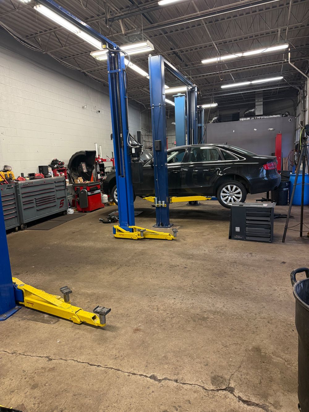Service bay with two-post lifts and a vehicle up on the lift